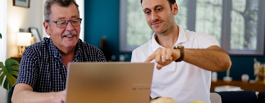 Aide d'un retraité avec ses démarches en ligne sur ordinateur